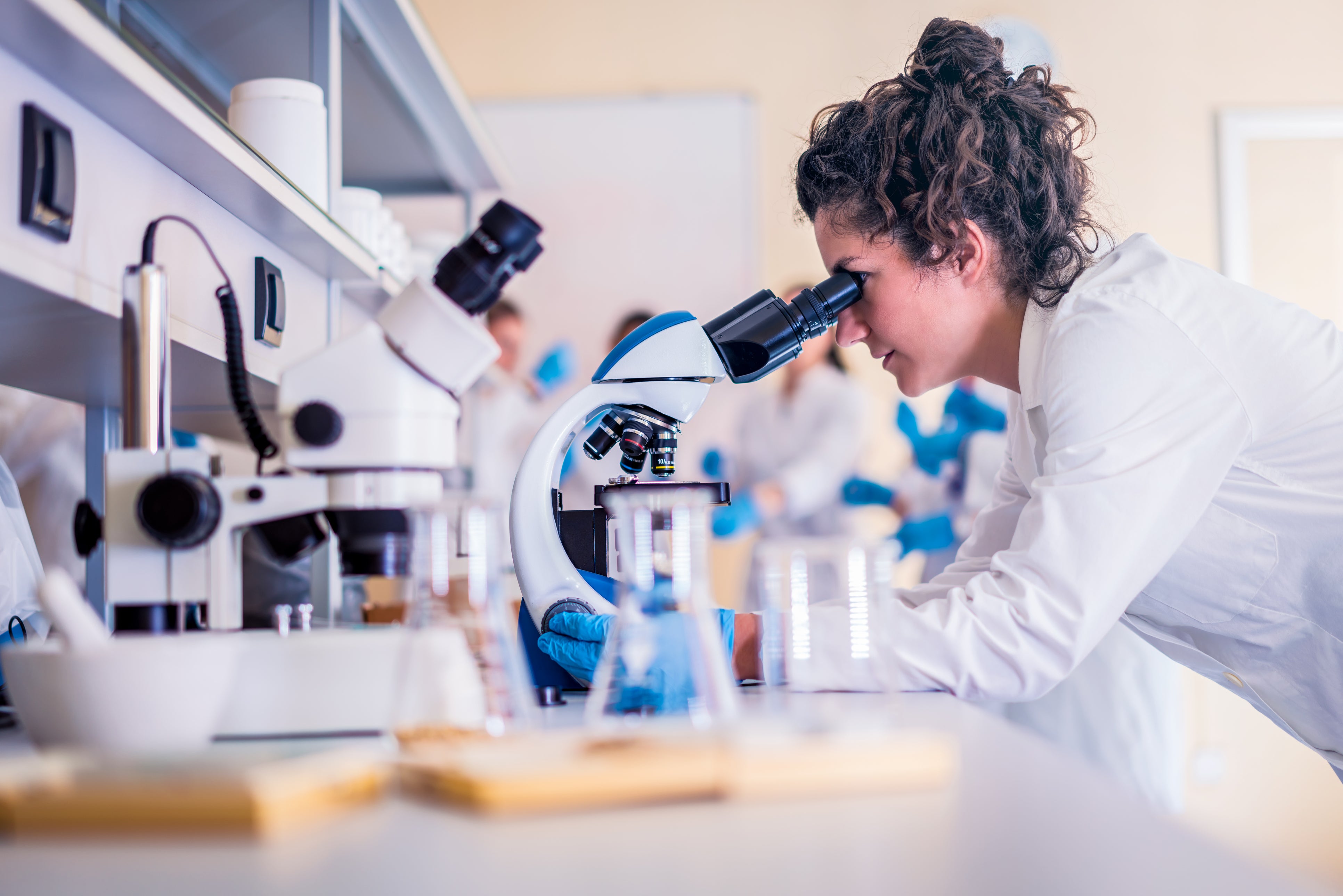 student in lab looking through microscope (c) iStock