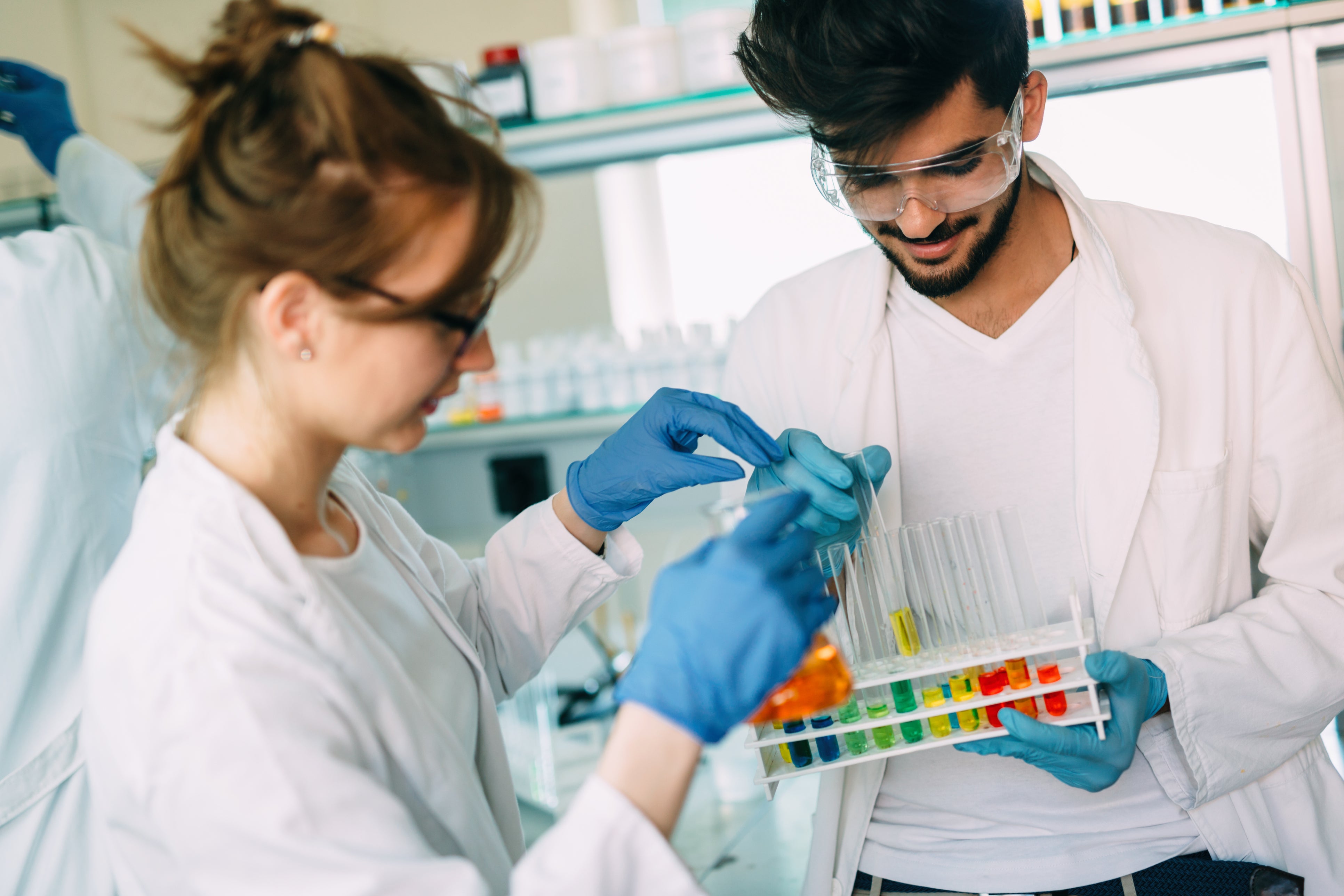 2 students looking at samples in test tubes (c) iStock