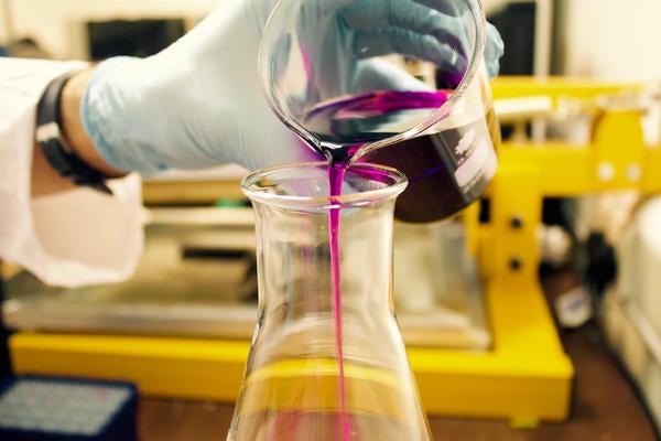 Purple Liquid being poured into lab vase