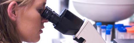 student looking through a microscope